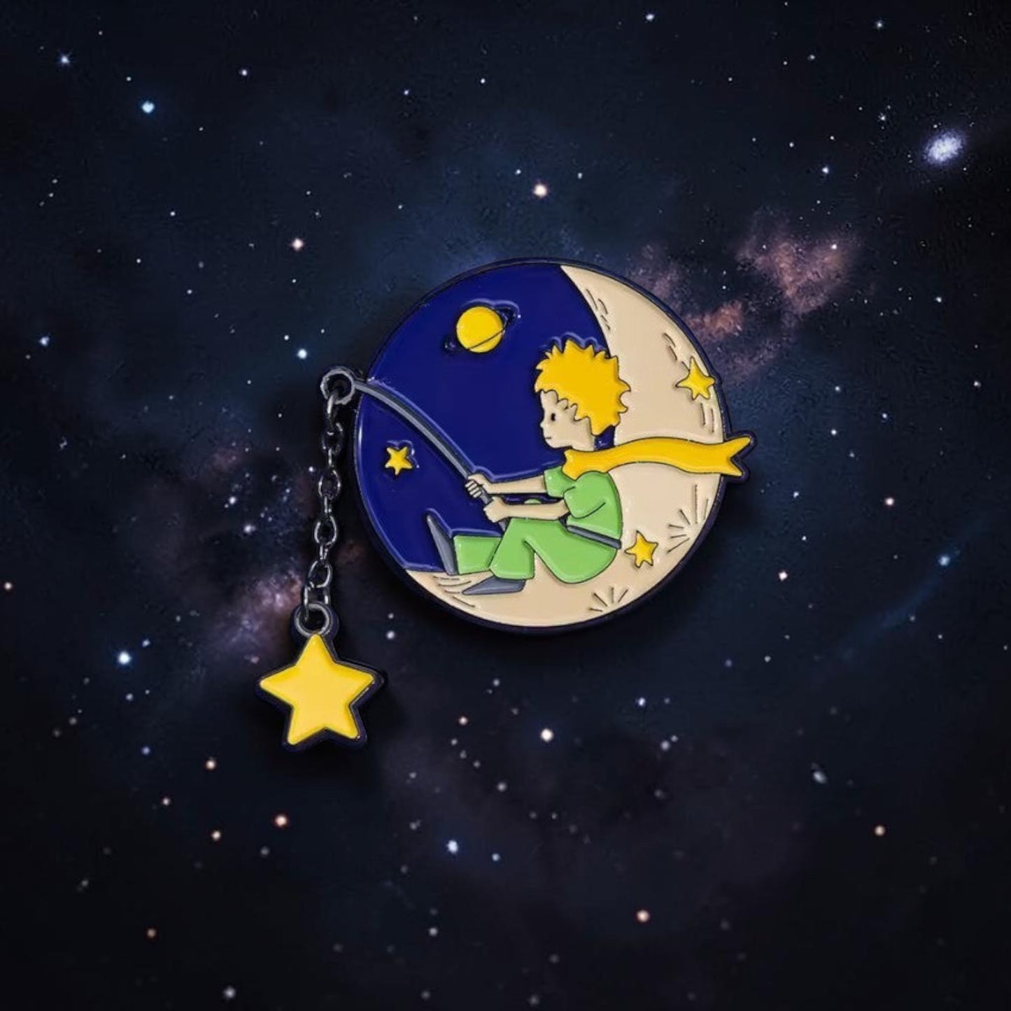 Pins & Co. The Little Prince enamel pin featuring the character fishing for stars on a crescent moon with a chain charm.