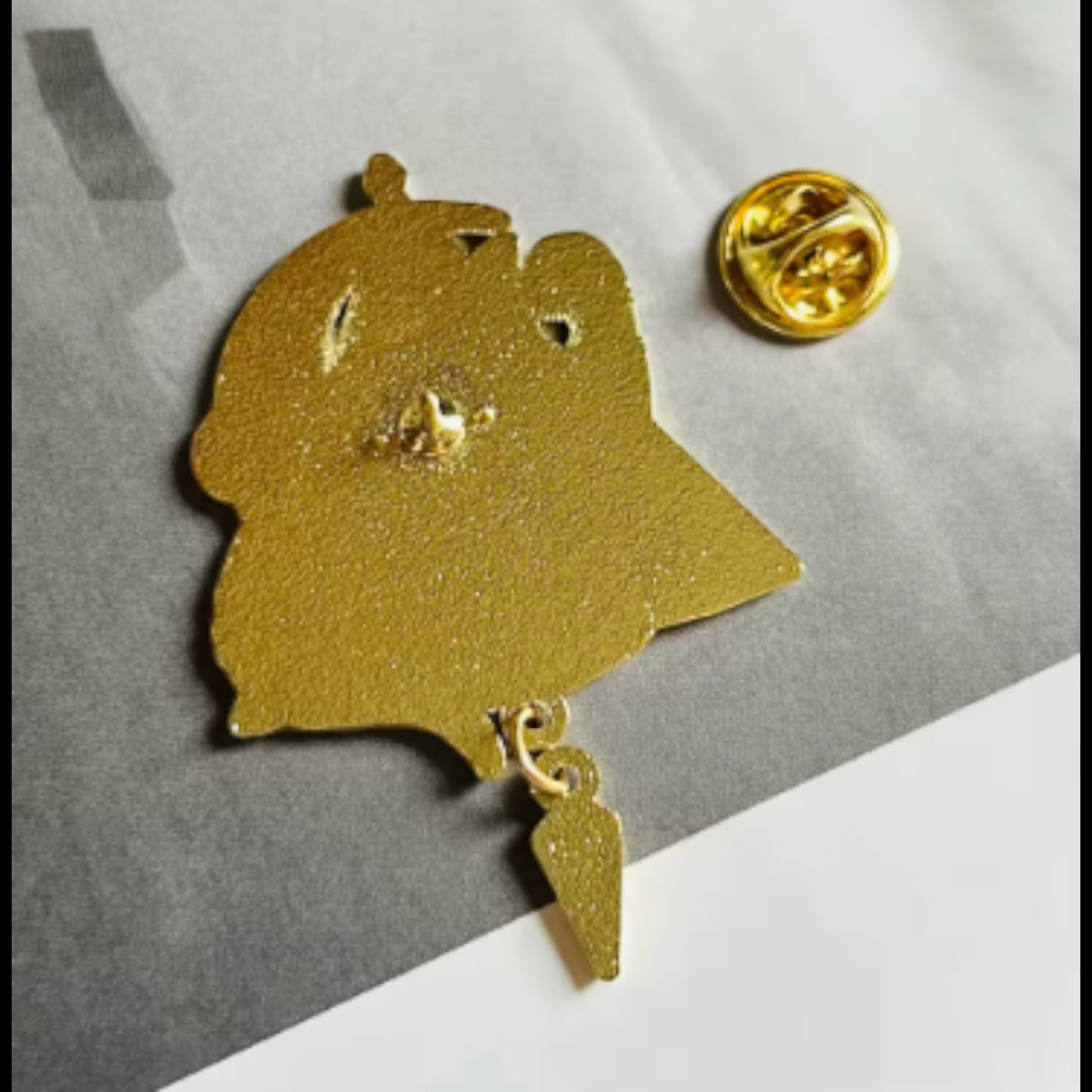 Pins & Co. Egyptian cat goddess enamel pin back view showing gold metal texture and secure butterfly clutch backing.
