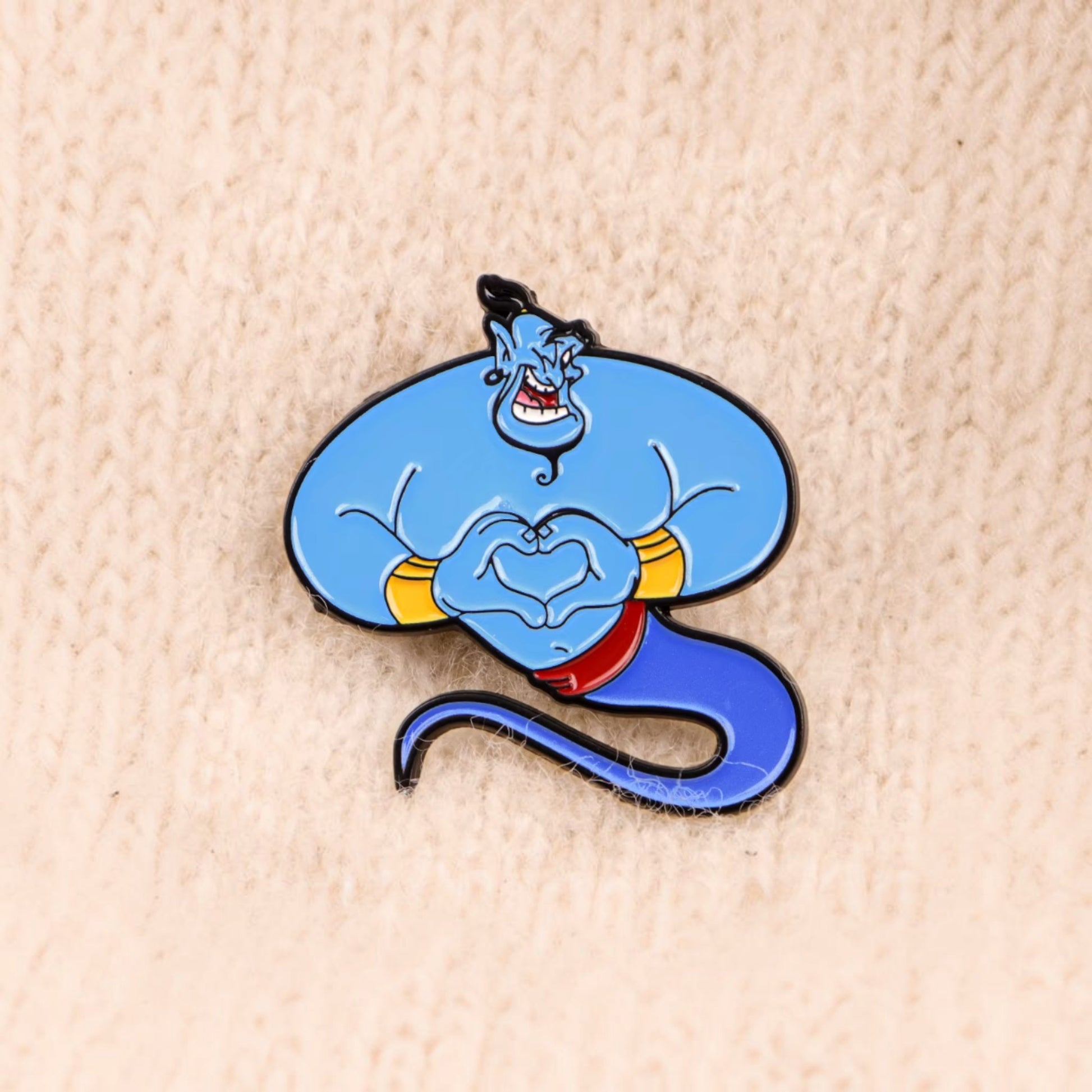 Pins & Co. Genie enamel lapel pin featuring the blue character making a heart shape with his hands.