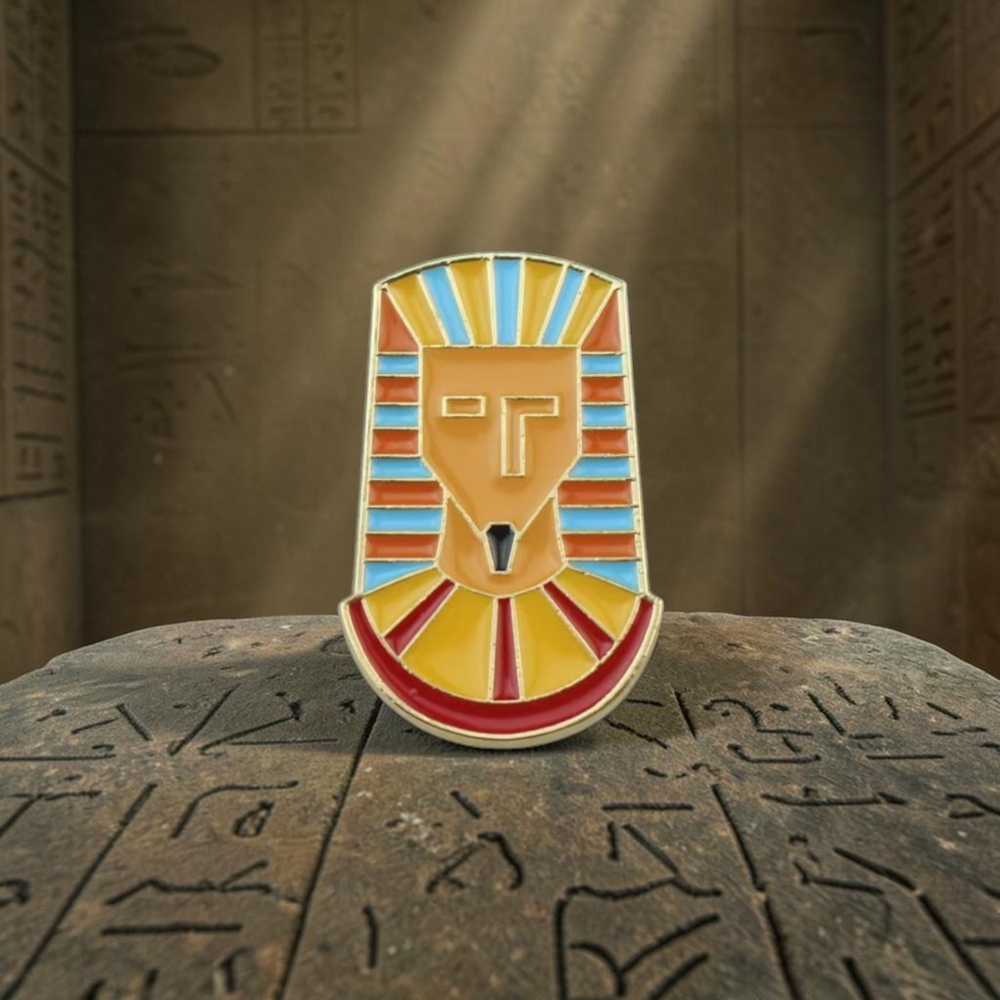 Pins & Co. pharaoh mask enamel lapel pin in vibrant orange, blue, and red with polished gold-tone metal detailing.