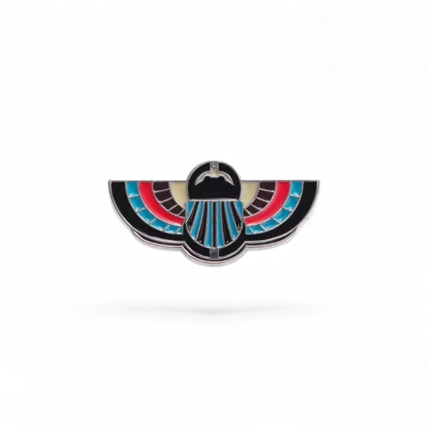 Pins & Co. Egyptian winged scarab lapel pin with black, red, and turquoise enamel on a polished metal base.