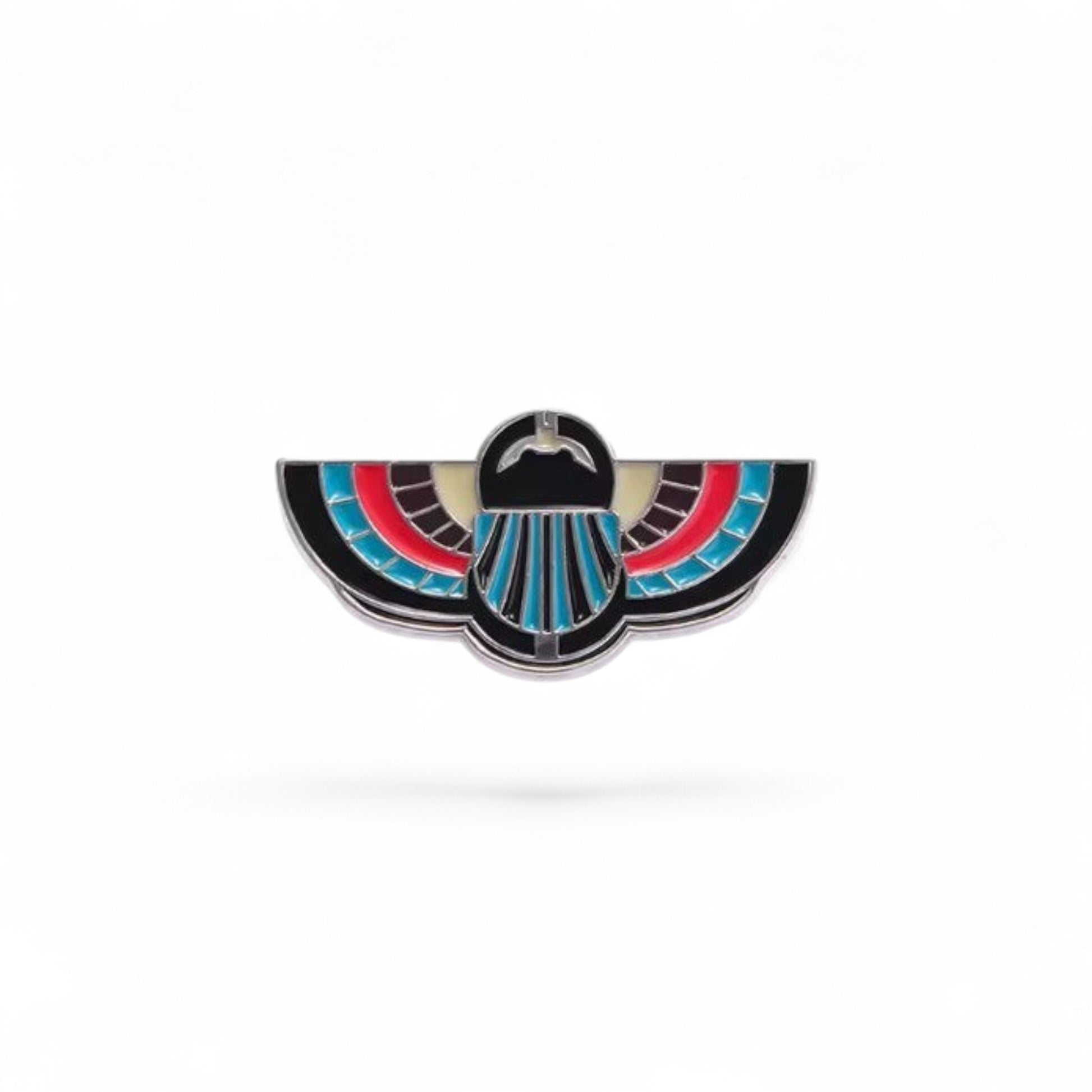 Pins & Co. Egyptian winged scarab lapel pin with black, red, and turquoise enamel on a polished metal base.