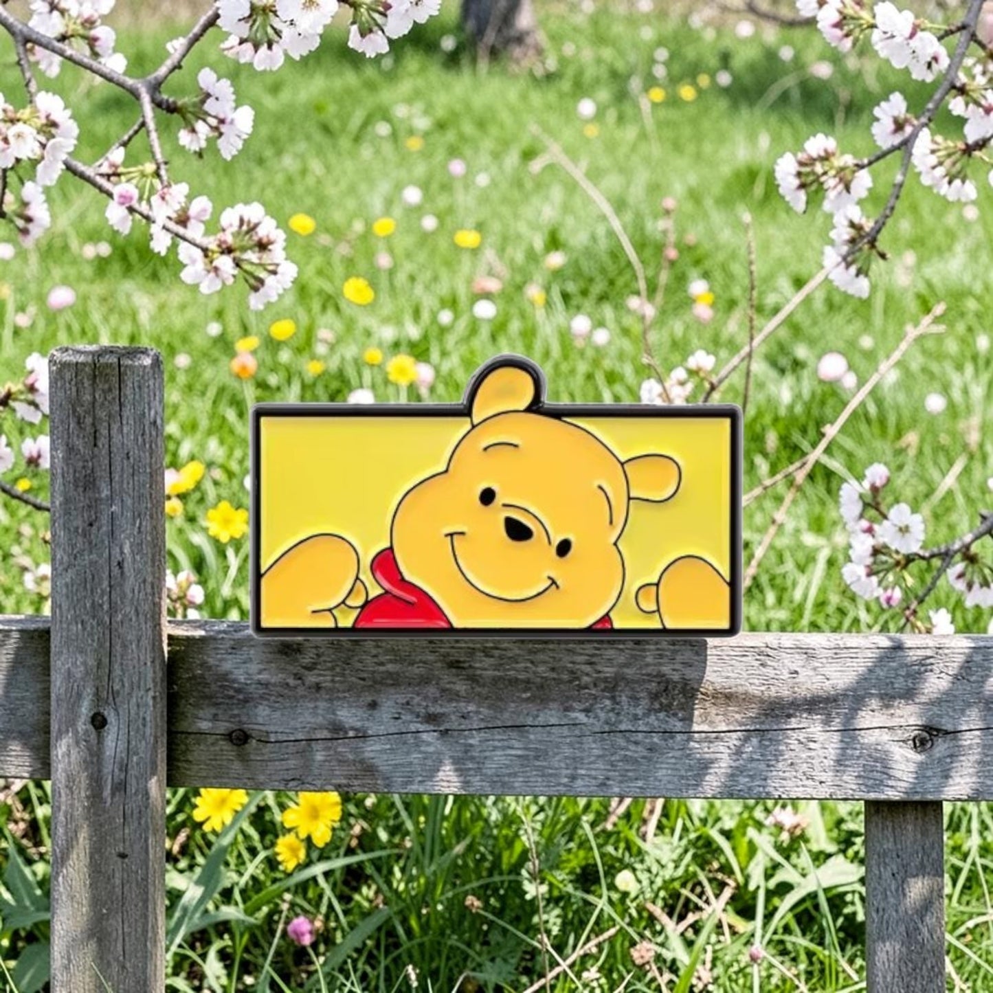 Pins & Co. Winnie the Pooh enamel pin featuring the cheerful bear in a peek-a-boo pose against a yellow background.